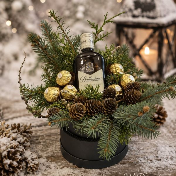 Upominek — butelka whisky i pralinki w czarnym okrągłym pudełku z gałązkami jodły i szyszkami — rękodzieło pracowni W Deseń